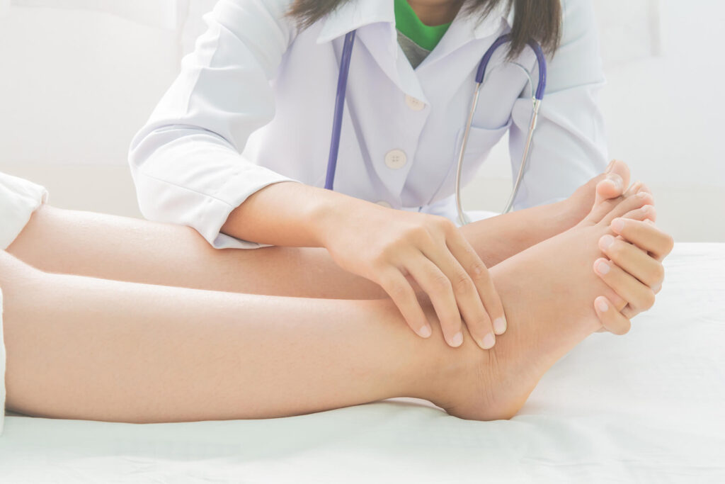 A doctor examines a patient's ankle and foot, checking for tenderness and range of motion as part of a clinical assessment - Centurion Orthopaedic Centre